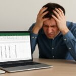 엑셀 앞에서 머리를 감싸쥐고 고민하는 사람